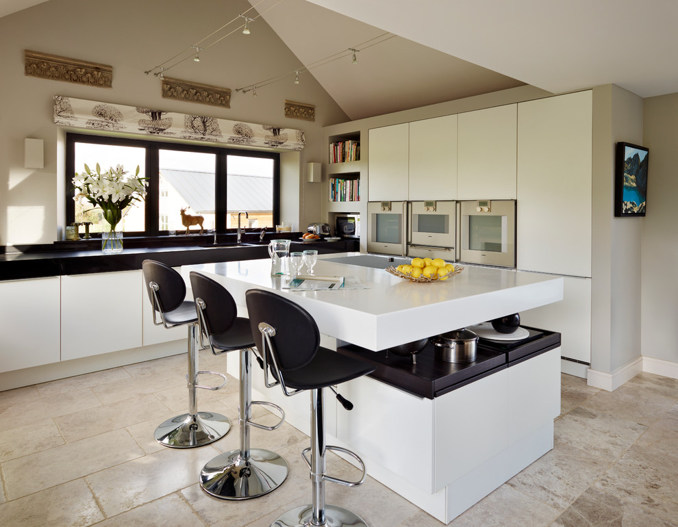This is an example of a mid-sized contemporary u-shaped eat-in kitchen in Essex with stainless steel appliances, marble floors, with island and flat-panel cabinets.