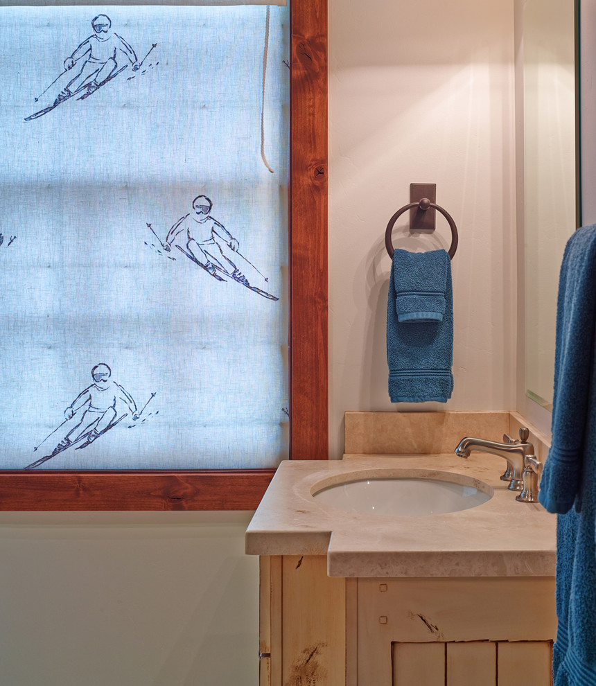Bathroom - small rustic bathroom idea with an undermount sink, shaker cabinets, light wood cabinets, solid surface countertops and beige walls
