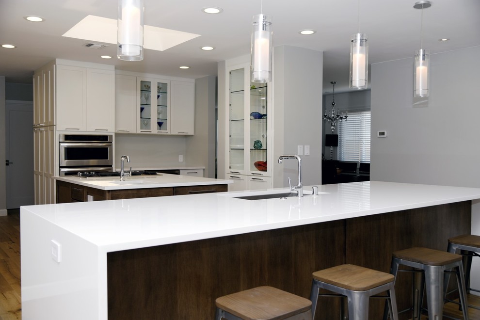 Example of a large transitional eat-in kitchen design in Los Angeles with an undermount sink, shaker cabinets, quartz countertops, stainless steel appliances, two islands and white cabinets