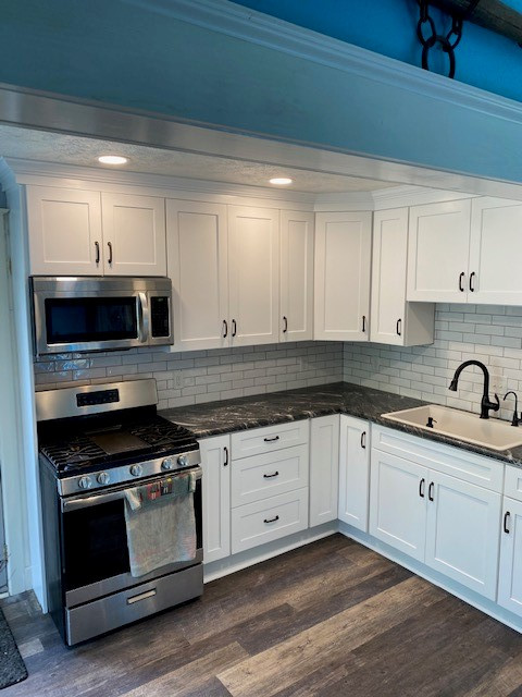 Small transitional l-shaped eat-in kitchen photo with a single-bowl sink, white cabinets, laminate countertops, white backsplash and ceramic backsplash