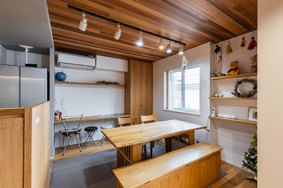 Inspiration pour une salle à manger ouverte sur la cuisine minimaliste de taille moyenne avec un mur blanc, un sol en bois brun, un sol marron et un plafond en bois.