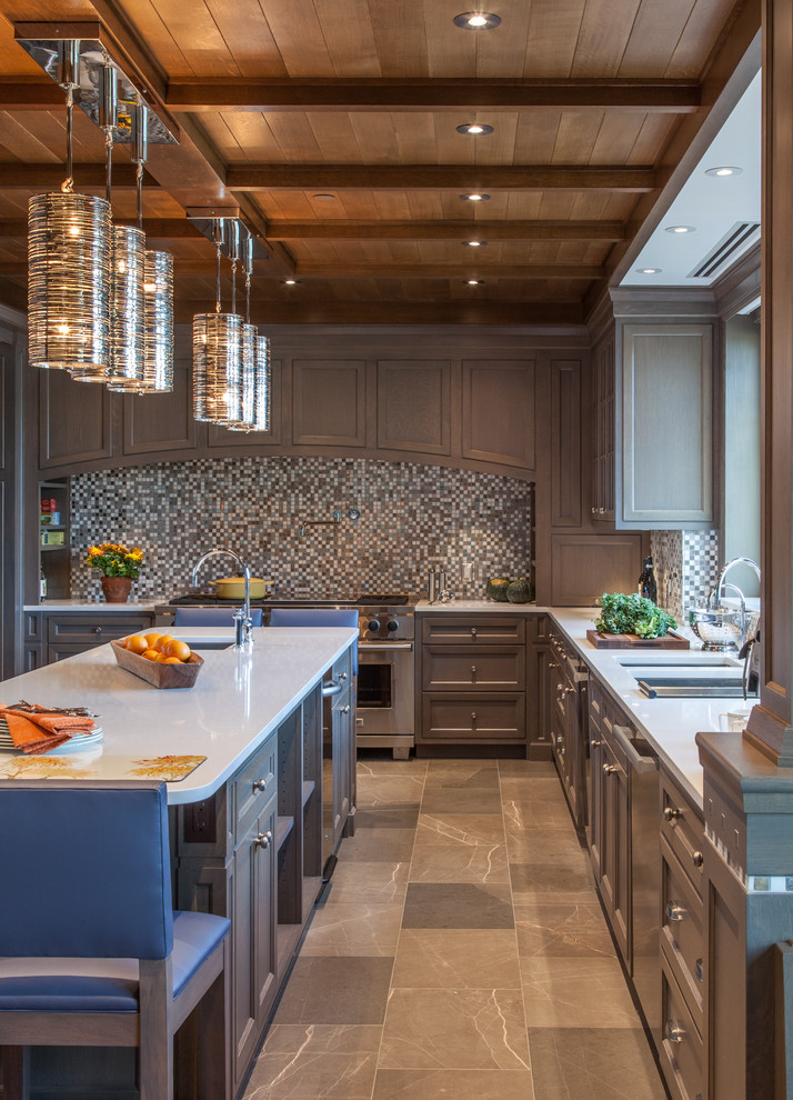 Photo of an expansive arts and crafts u-shaped eat-in kitchen in Burlington with recessed-panel cabinets, grey cabinets, stainless steel appliances, with island, a double-bowl sink, solid surface benchtops, multi-coloured splashback, mosaic tile splashback, porcelain floors and brown floor.