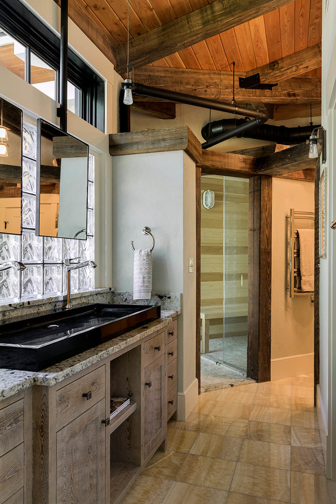 This is an example of a mid-sized industrial master bathroom in Boston with raised-panel cabinets, distressed cabinets, an alcove shower, beige walls, ceramic floors, a trough sink and granite benchtops.