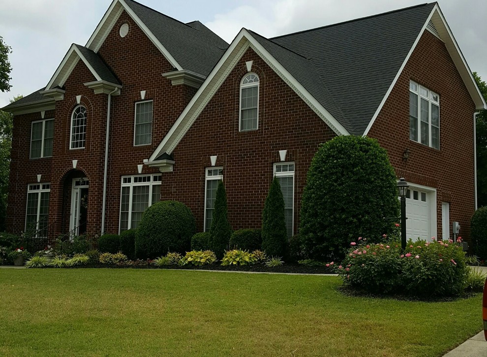 This is an example of a large traditional two-storey brick red exterior in Charlotte.