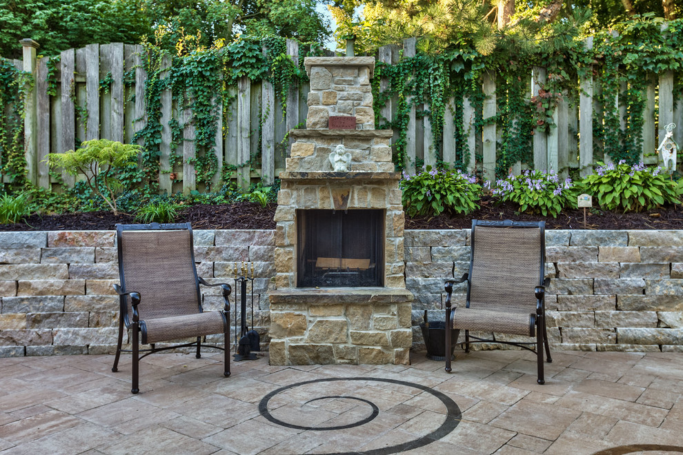 This is an example of a mid-sized contemporary backyard patio in Omaha with a fire feature, concrete pavers and no cover.