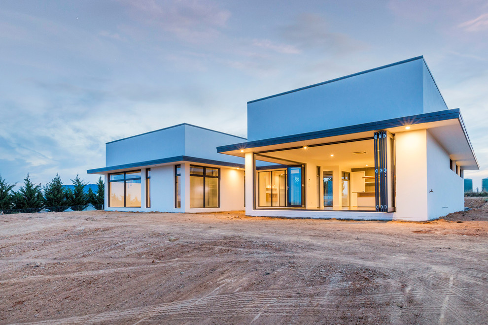 Photo of a large contemporary one-storey stucco white exterior in Canberra - Queanbeyan.
