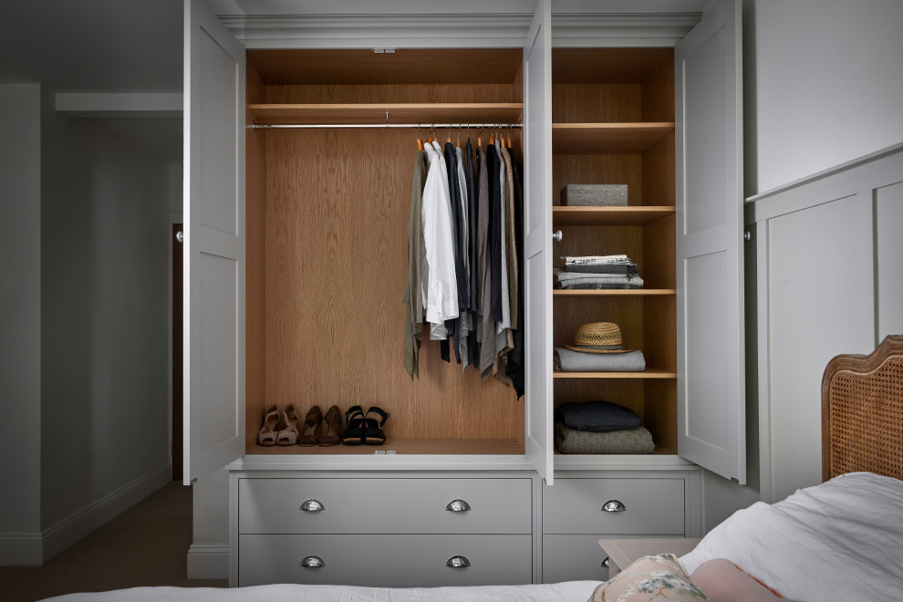 Example of a mid-sized classic gender-neutral carpeted reach-in closet design in West Midlands with shaker cabinets and gray cabinets