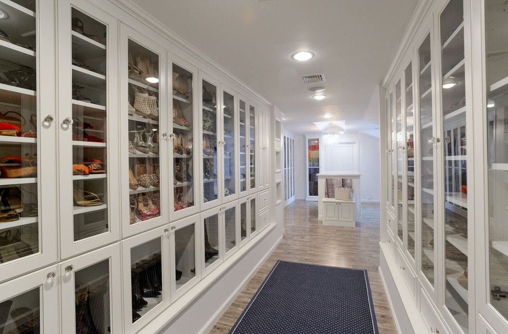 This is an example of a traditional dressing room in New York with white cabinets.