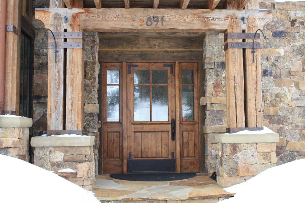 Example of a mid-sized mountain style two-story brick gray front door design in Denver with beige walls and a medium wood front door