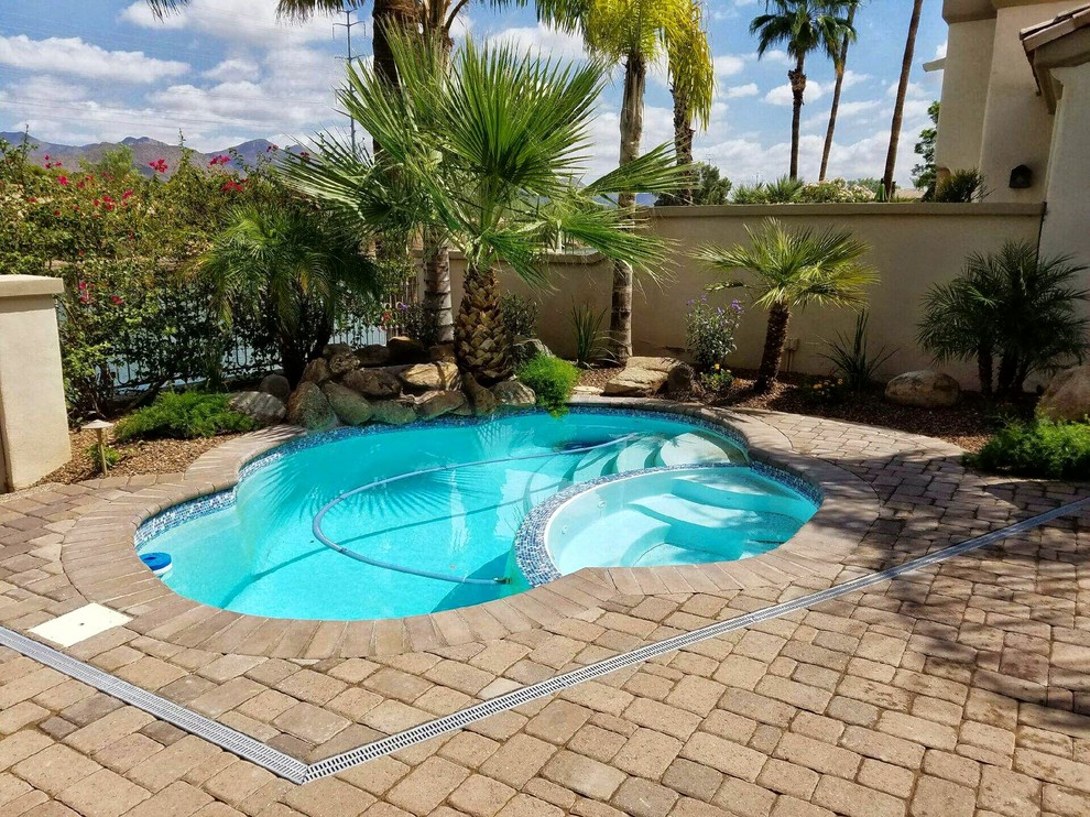 Photo of a small traditional backyard custom-shaped pool in San Diego with a hot tub.