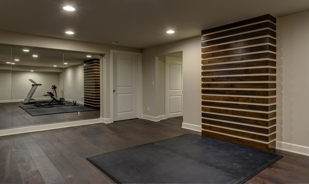 This is an example of an expansive contemporary look-out basement in Denver with grey walls, dark hardwood floors, a ribbon fireplace, a tile fireplace surround and brown floor.