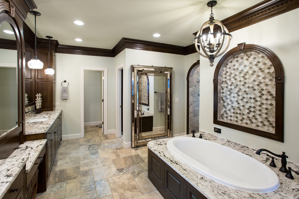Photo of an expansive traditional master bathroom in Birmingham with raised-panel cabinets, dark wood cabinets, a drop-in tub, an open shower, multi-coloured tile, ceramic tile, grey walls, travertine floors, an undermount sink, granite benchtops and beige floor.