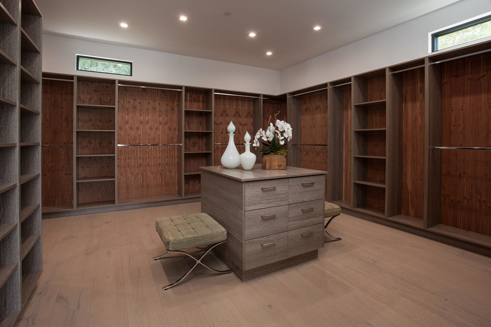 Design ideas for a large modern gender neutral walk-in wardrobe in Los Angeles with flat-panel cabinets, medium wood cabinets and light hardwood flooring.