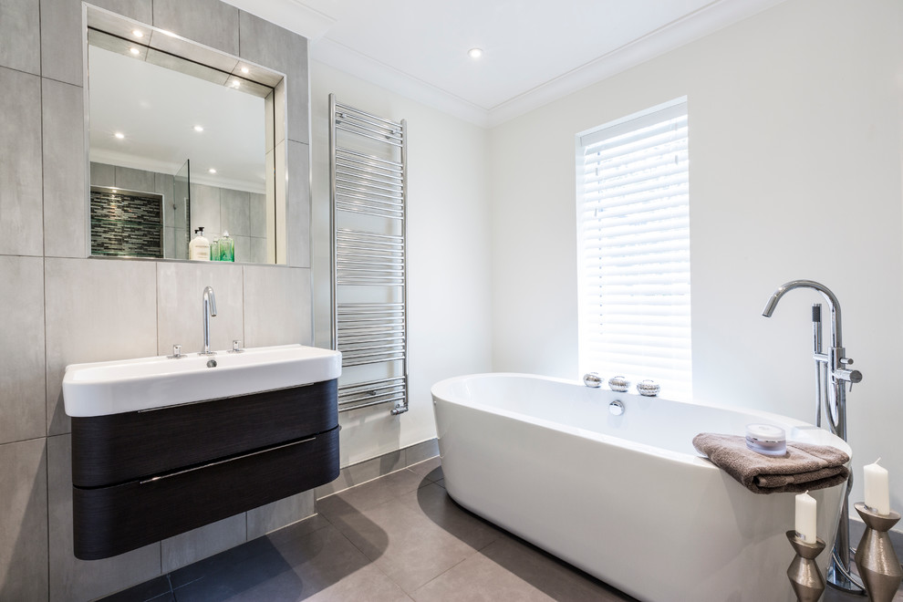 This is an example of a small contemporary master bathroom in Surrey with dark wood cabinets.