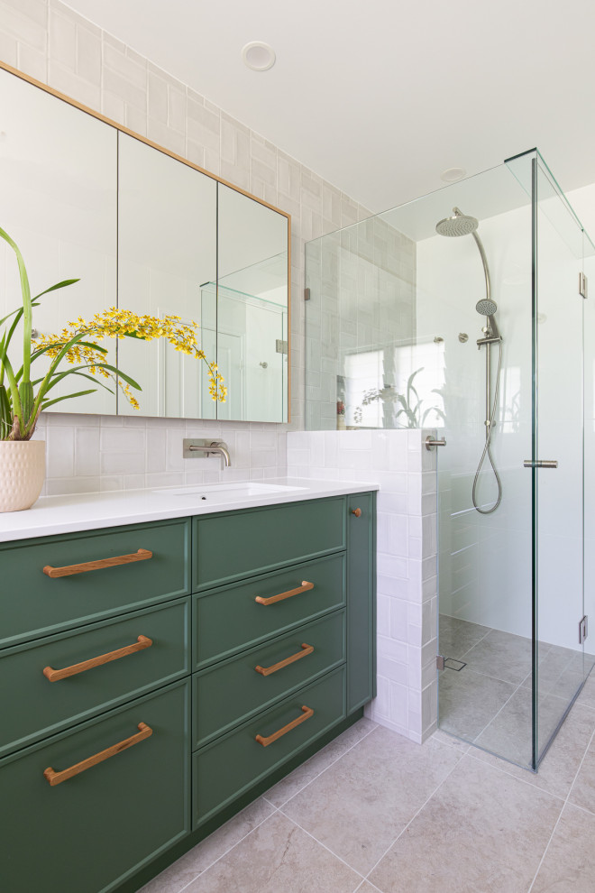This is an example of a large contemporary kids bathroom in Brisbane with shaker cabinets, green cabinets, a corner shower, a one-piece toilet, gray tile, ceramic tile, white walls, ceramic floors, an undermount sink, engineered quartz benchtops, beige floor, a hinged shower door, white benchtops, a niche, a double vanity, a built-in vanity and wood.