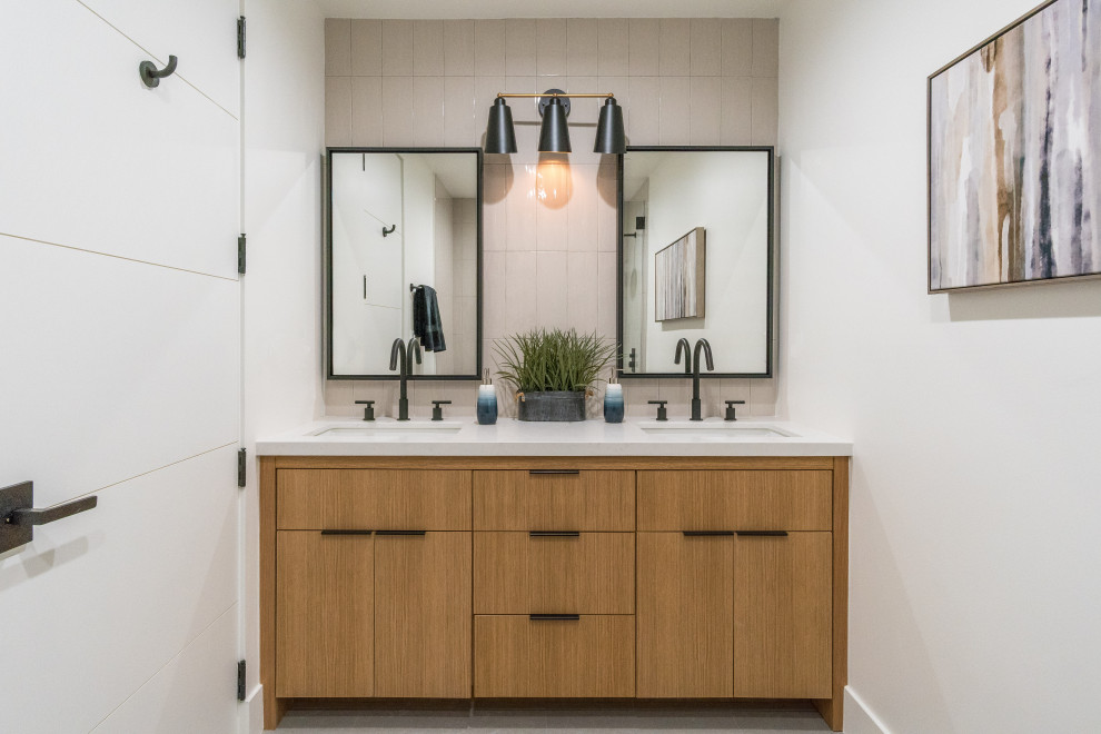 Photo of a midcentury 3/4 bathroom in Los Angeles with flat-panel cabinets, light wood cabinets, beige tile, white walls, an undermount sink and white benchtops.