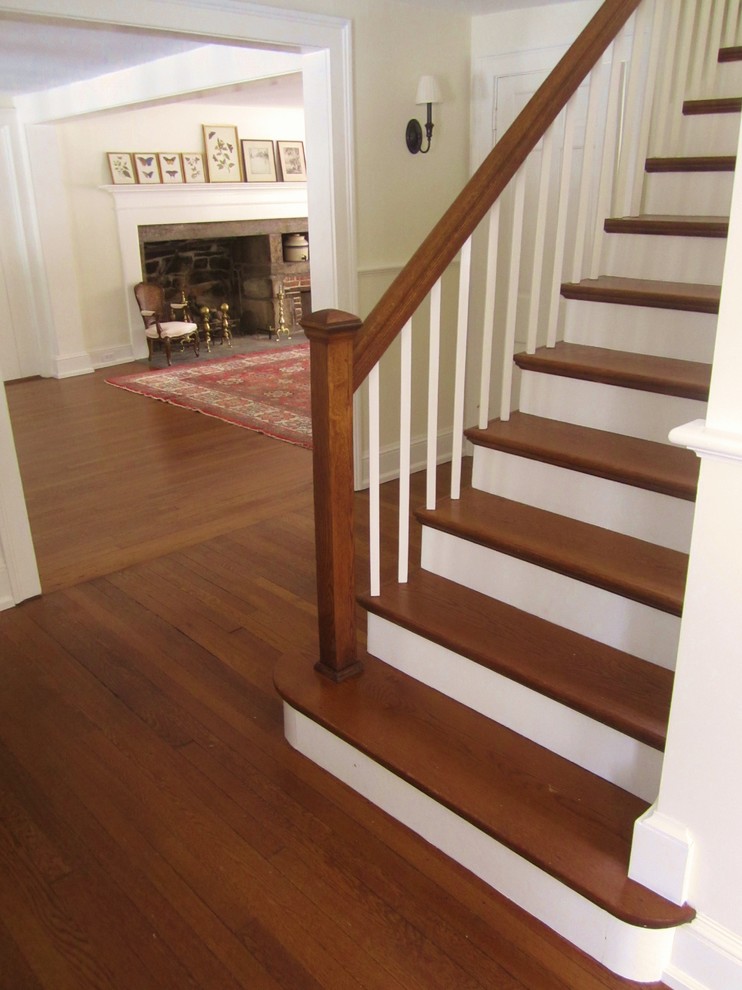 Photo of a large traditional wood straight staircase in New York with painted wood risers.