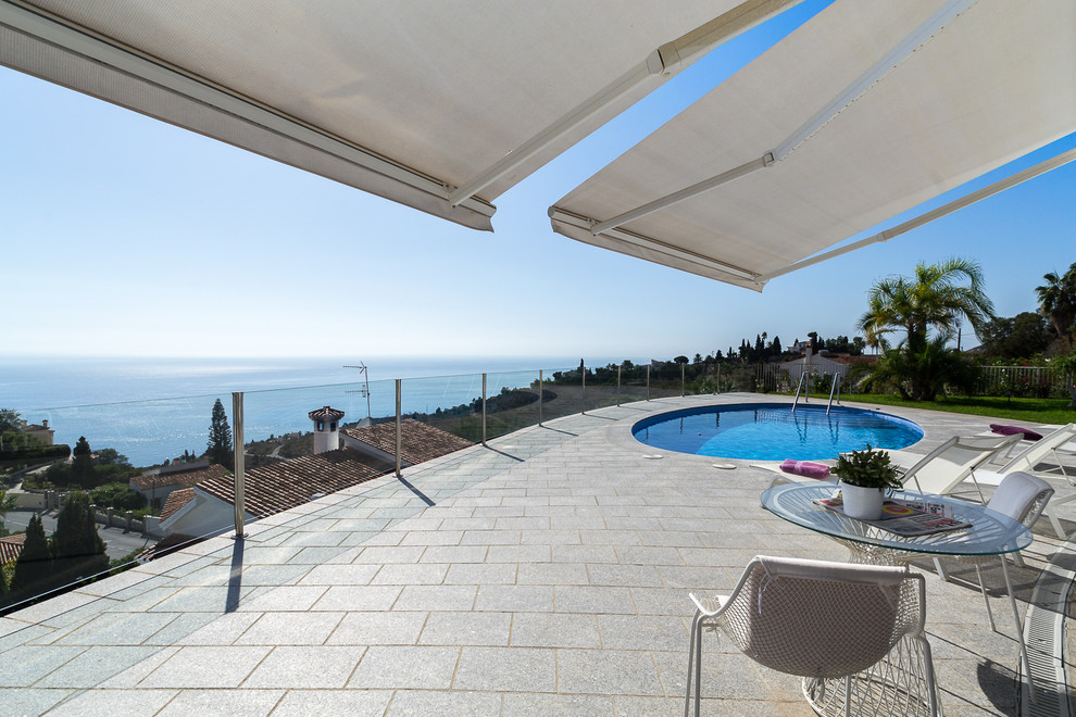 Inspiration for a large contemporary rooftop round lap pool in Other with brick pavers.