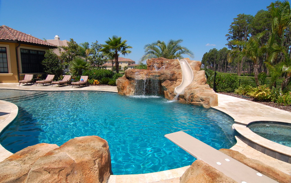 This is an example of a mediterranean pool in Tampa with a water slide.