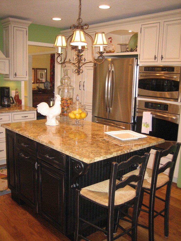 Inspiration for a transitional medium tone wood floor kitchen remodel in Indianapolis with a farmhouse sink, recessed-panel cabinets, black cabinets, granite countertops, stainless steel appliances, green walls and an island