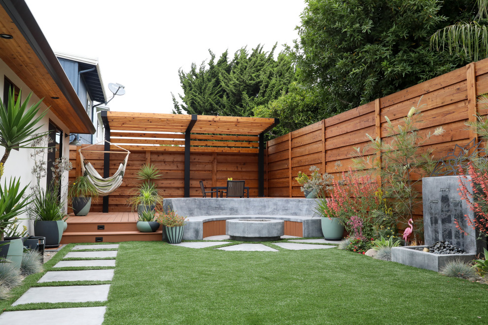 Foto de jardín de secano moderno de tamaño medio en verano en patio trasero con cascada, exposición total al sol, adoquines de hormigón y con madera