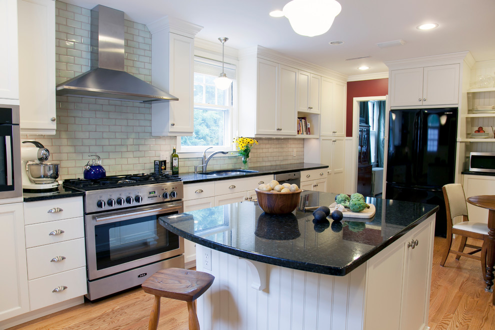 Traditional single-wall eat-in kitchen in Bridgeport with black appliances, subway tile splashback, an undermount sink, recessed-panel cabinets, white cabinets, granite benchtops and green splashback.