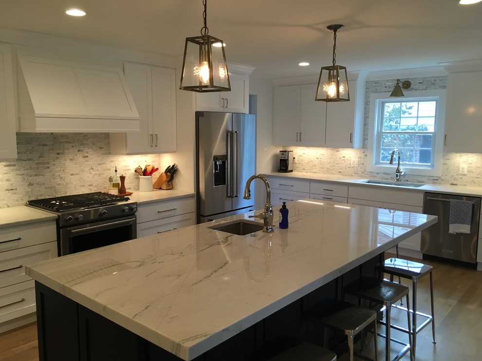 Open concept kitchen - mid-sized transitional u-shaped brown floor open concept kitchen idea in DC Metro with an undermount sink, shaker cabinets, white cabinets, gray backsplash, stainless steel appliances, an island and white countertops