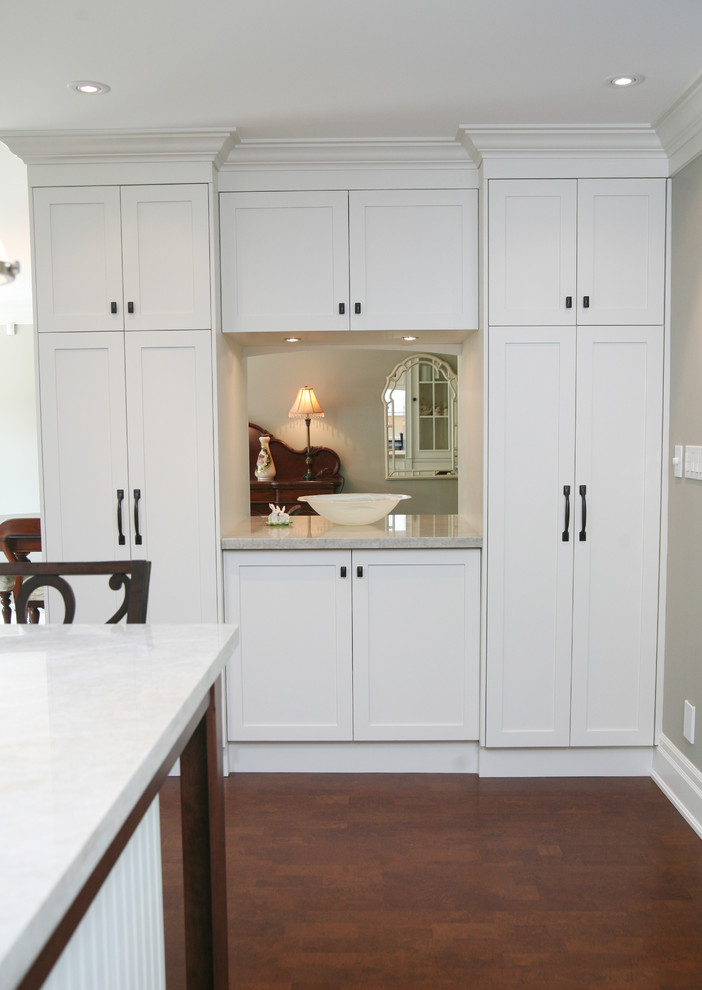 Eat-in kitchen - large transitional l-shaped dark wood floor and brown floor eat-in kitchen idea in Toronto with an undermount sink, shaker cabinets, white cabinets, stainless steel appliances and an island