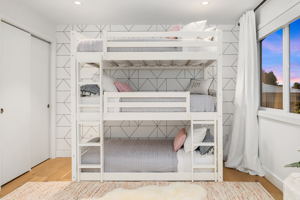 シアトルにある小さなミッドセンチュリースタイルのおしゃれな客用寝室 (白い壁、淡色無垢フローリング、暖炉なし、茶色い床、壁紙) のインテリア