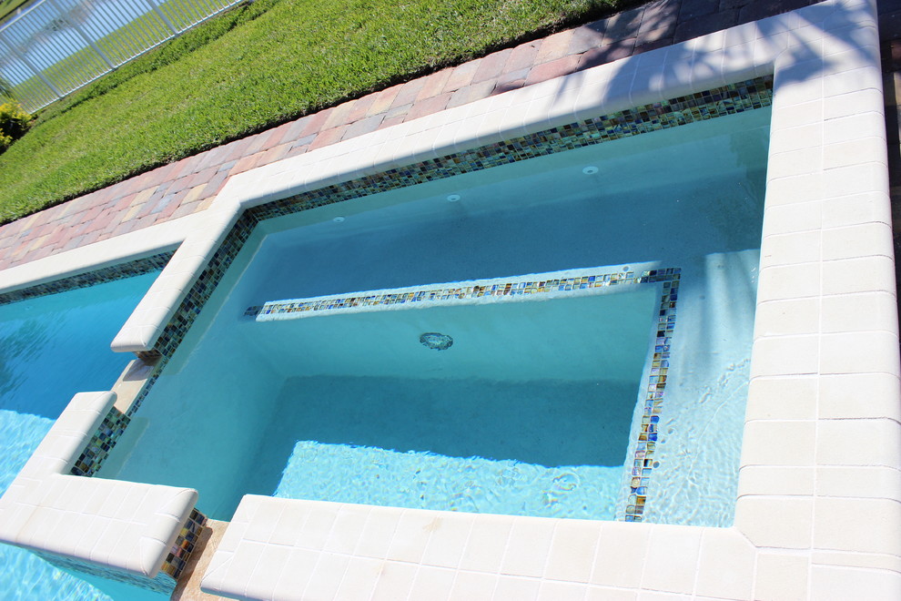 Hot tub - transitional backyard brick and rectangular hot tub idea in Miami