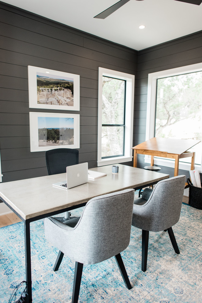 This is an example of a mid-sized transitional study room in Austin with grey walls, light hardwood floors, a freestanding desk and beige floor.