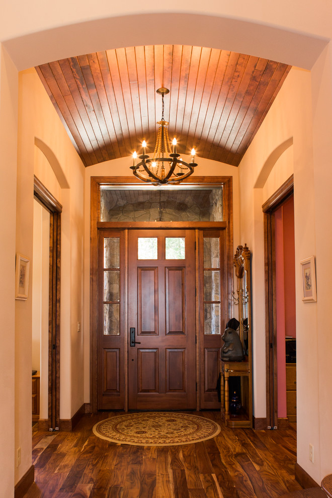 This is an example of a small front door in Portland with white walls, dark hardwood floors, a single front door and a dark wood front door.