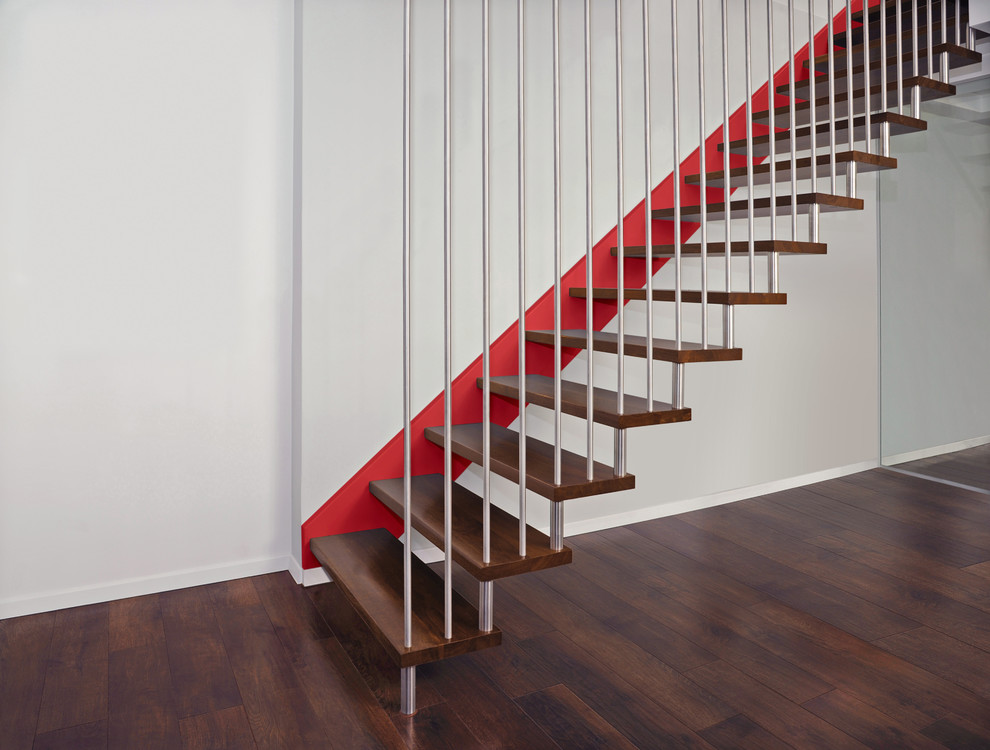 This is an example of a large modern wood straight staircase in Dresden with open risers and metal railing.