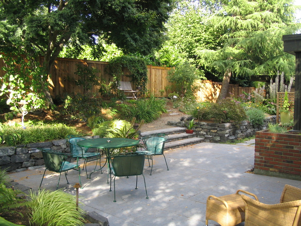 Traditional backyard garden in Seattle with a retaining wall.