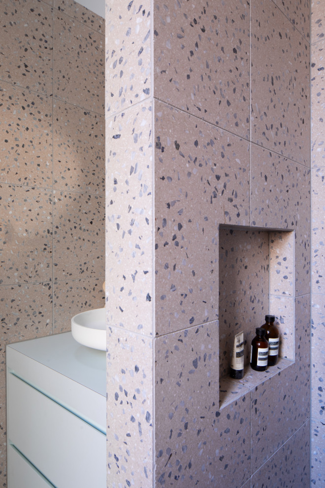 Design ideas for a mid-sized eclectic master bathroom in Melbourne with flat-panel cabinets, blue cabinets, a drop-in tub, an open shower, a two-piece toilet, pink tile, stone tile, pink walls, terrazzo floors, a vessel sink, laminate benchtops, pink floor, blue benchtops, a laundry, a single vanity and a built-in vanity.