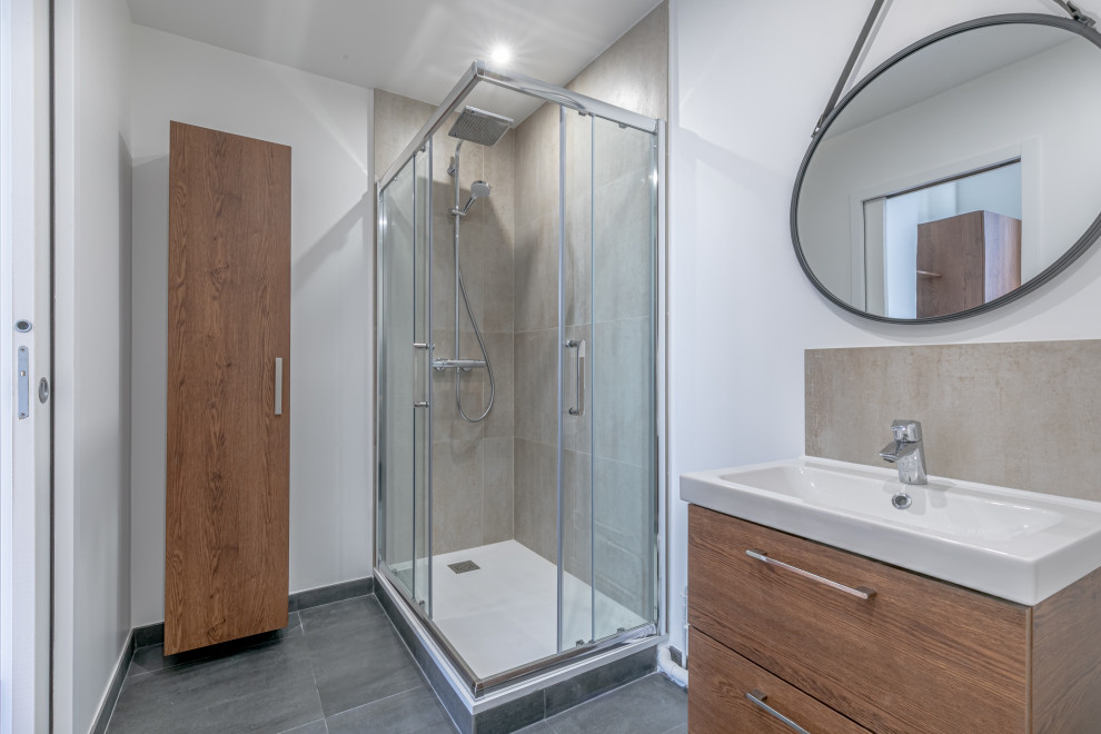 Example of a small transitional beige tile and ceramic tile ceramic tile, gray floor and single-sink sliding shower door design in Paris with a wall-mount toilet, white walls and a console sink