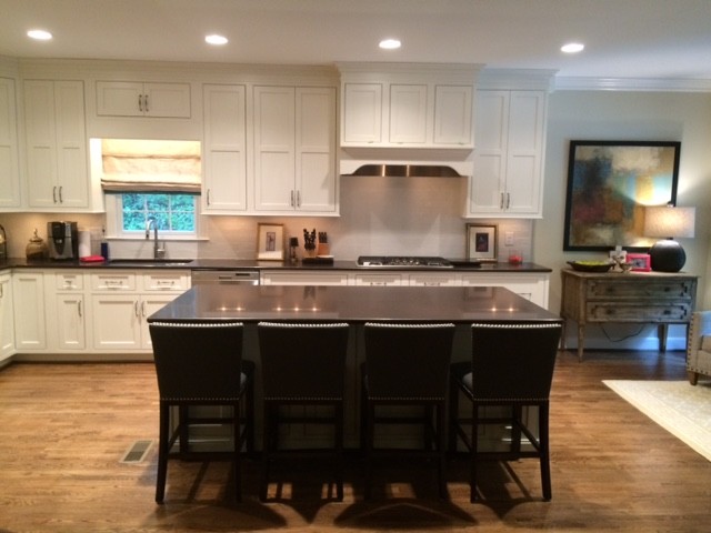 Mid-sized transitional galley medium tone wood floor eat-in kitchen photo in Birmingham with an undermount sink, shaker cabinets, white cabinets, quartzite countertops, white backsplash, subway tile backsplash, stainless steel appliances and an island