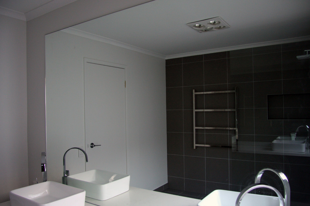 Photo of a mid-sized modern kids bathroom in Melbourne with furniture-like cabinets, dark wood cabinets and engineered quartz benchtops.