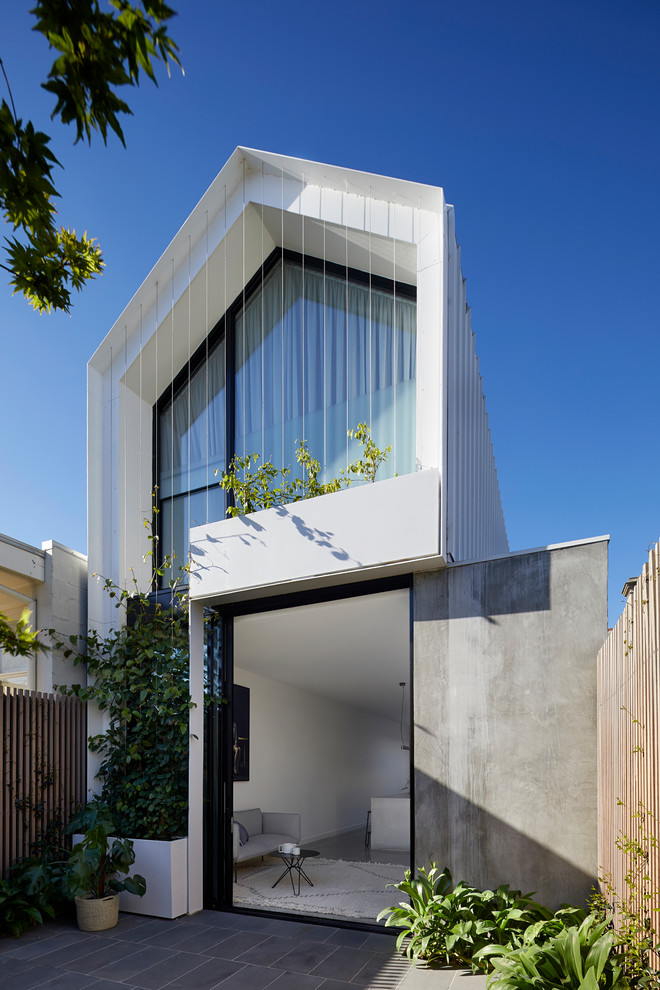 This is an example of a contemporary two-storey glass white house exterior in Melbourne with a gable roof and a metal roof.