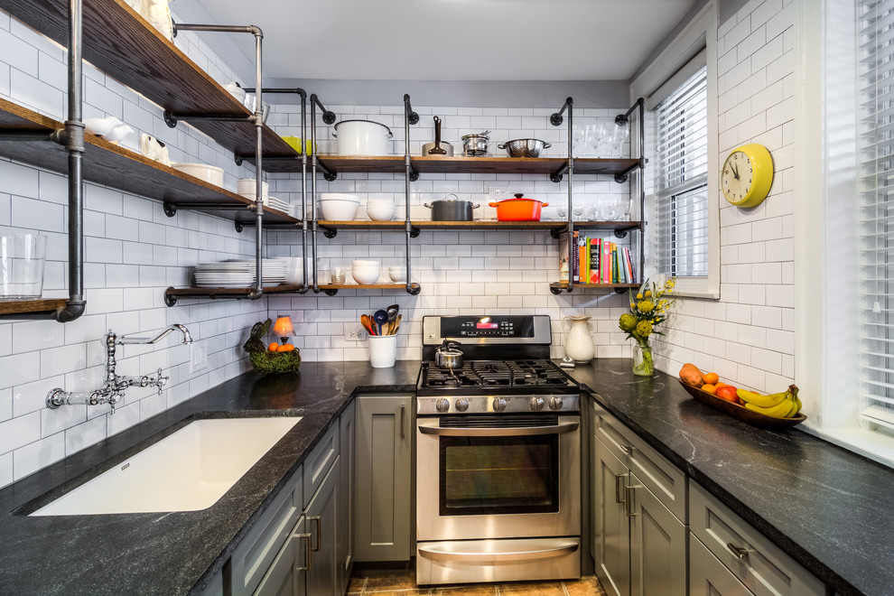 Design ideas for a small industrial u-shaped separate kitchen in Boston with an undermount sink, shaker cabinets, grey cabinets, white splashback, subway tile splashback, no island, stainless steel appliances, soapstone benchtops, slate floors and brown floor.