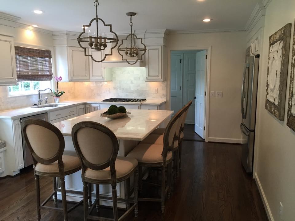 Eat-in kitchen - mid-sized transitional l-shaped dark wood floor eat-in kitchen idea with an undermount sink, recessed-panel cabinets, white cabinets, granite countertops, white backsplash, stainless steel appliances and an island