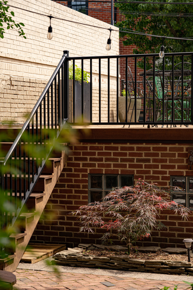 Cette photo montre une petite terrasse arrière et au rez-de-chaussée rétro avec aucune couverture, un garde-corps en métal et un foyer extérieur.
