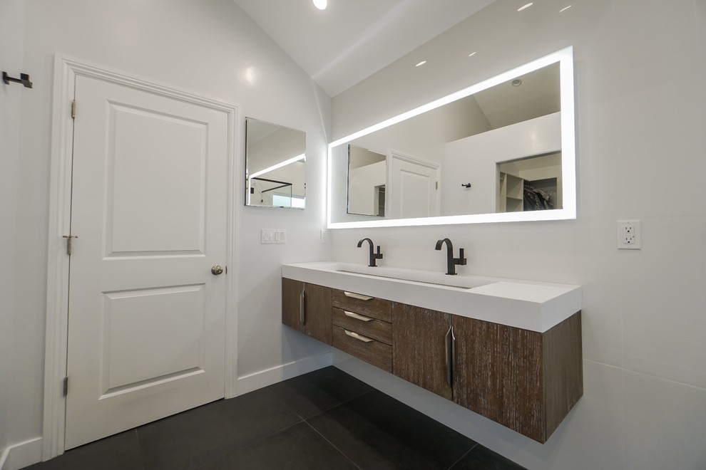 Inspiration for a mid-sized modern master bathroom in Los Angeles with brown cabinets, white walls, a wall-mount sink, black floor and white benchtops.