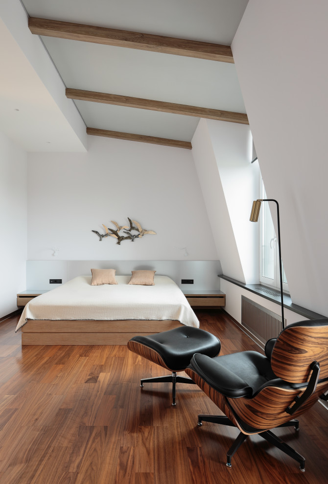 На фото: спальня среднего размера на мансарде в скандинавском стиле с белыми стенами, паркетным полом среднего тона, коричневым полом и балками на потолке