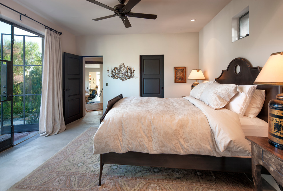 Inspiration for a country bedroom in Santa Barbara with beige walls, concrete floors and no fireplace.