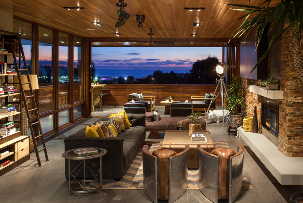 Example of an island style living room design in San Diego with a ribbon fireplace
