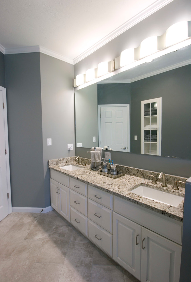 Example of a mid-sized transitional master gray tile and ceramic tile ceramic tile walk-in shower design with an undermount sink, raised-panel cabinets, white cabinets, granite countertops, a two-piece toilet and gray walls