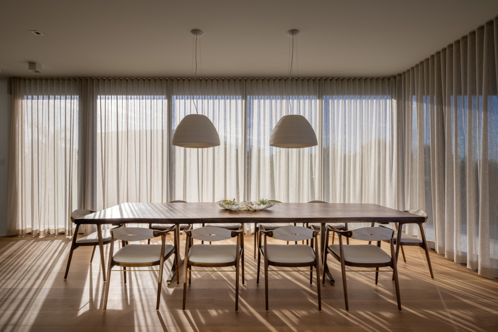 Ispirazione per una sala da pranzo moderna con pavimento in legno massello medio e pavimento marrone