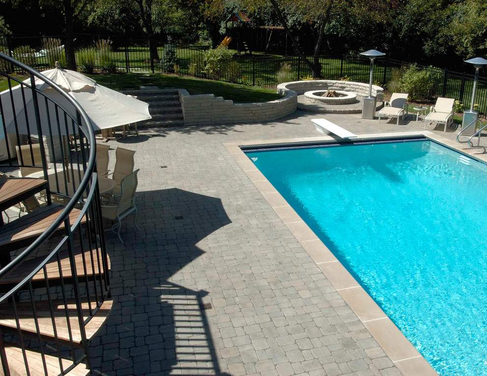 Example of a large eclectic backyard concrete paver and rectangular pool design in Chicago