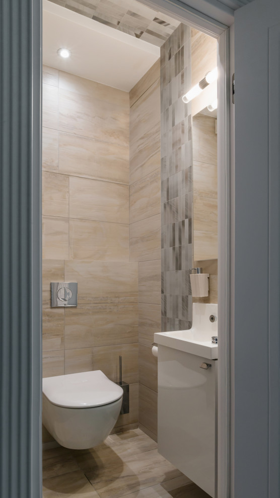 Inspiration for a contemporary powder room in Moscow with flat-panel cabinets, white cabinets, a wall-mount toilet, beige tile and beige floor.